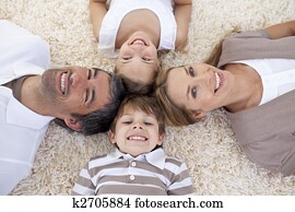 Family lying on floor with heads together Family lying on floor with heads together