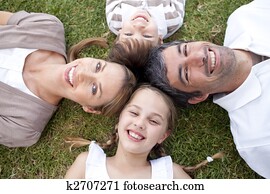 Smiling family lying in a park Smiling family lying in a park