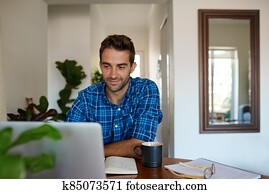 Young man working from home using a laptop Young man working from home using a laptop
