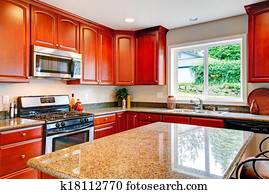 Bright kitchen room with cherry wood storage combination 