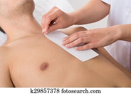 Person Hands Waxing Man's Chest Person Hands Waxing Man's Chest