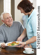 Senior Man Being Served Meal By Carer Senior Man Being Served Meal By Carer