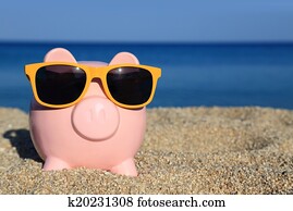 Summer piggy bank with sunglasses on the beach Summer piggy bank with sunglasses on the beach