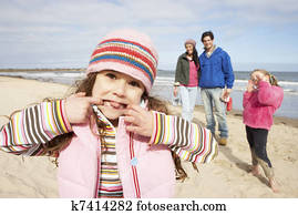 Family Walking Along Winter Beach Family Walking Along Winter Beach