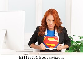 serious woman shows her superman uniform underneath her clothes. Super businesswoman sitting in office and tearing her clothes serious woman shows her superman uniform underneath her clothes. Super businesswoman sitting in office and tearing her clothes