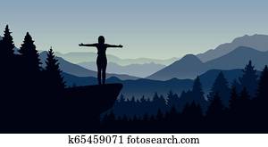 happy woman stands on a cliff in the forest with mountain view nature landscape happy woman stands on a cliff in the forest with mountain view nature landscape