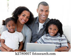 Happy Afro-American family using a laptop in the living-room