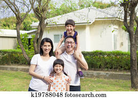 Happy family standing before their house