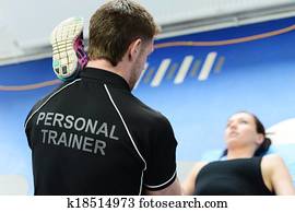 Personal trainer helping with stretches Personal trainer helping with stretches