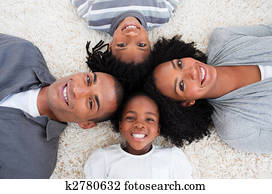 Smiling Afro-American young family lying on floor