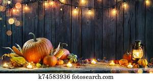 Thanksgiving - Pumpkins On Rustic Table With Candles And String Lights Thanksgiving - Pumpkins On Rustic Table With Candles And String Lights