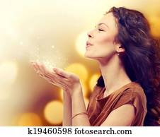 Young Woman Blowing Magic Dust with Stars from her Hands Young Woman Blowing Magic Dust with Stars from her Hands