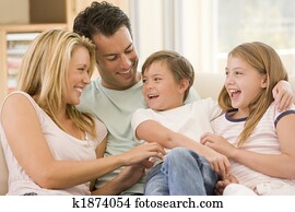 Family sitting in living room smiling
