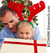 Father and his daughter opening Christmas gifts