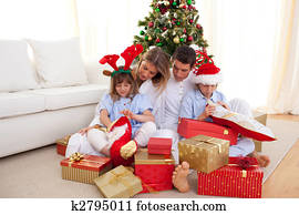 Portrait of a happy family opening Christmas gifts