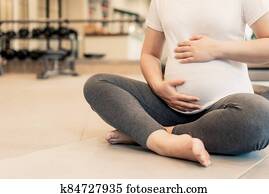 Active pregnant woman exercise in fitness center. Active pregnant woman exercise in fitness center.