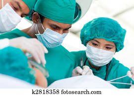Multi-ethnic surgeons during a surgery Multi-ethnic surgeons during a surgery