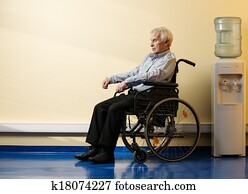 Thoughtful senior man in wheelchair in nursing home