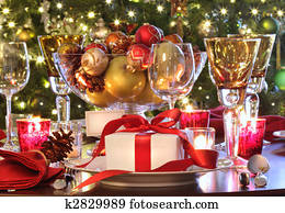 Holiday table setting with red ribboned gift Holiday table setting with red ribboned gift