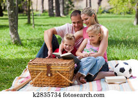 Happy family reading in a park Happy family reading in a park