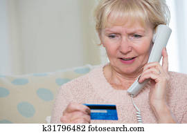 Senior Woman Giving Credit Card Details On The Phone