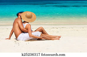 Couple in white relax on a beach at Maldives Couple in white relax on a beach at Maldives