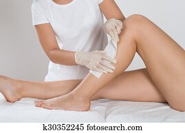 Beautician Waxing Leg Of Woman Beautician Waxing Leg Of Woman