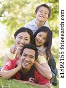 Family lying outdoors smiling Family lying outdoors smiling