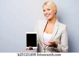 publicidad, su, product., hermoso, joven, mujer de negocios, actuación, ella, tableta de digital, mientras, posición, contra, gris, plano de fondo