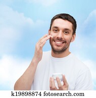 beautiful smiling man applyin cream beautiful smiling man applyin cream