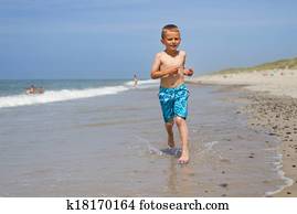 Boy running and smiling at beach