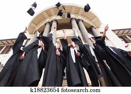 group of graduates throwing graduation hats in the air group of graduates throwing graduation hats in the air