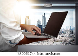 businessman working on his laptop in office with london city background businessman working on his laptop in office with london city background
