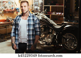 Handsome biker being circled with tools