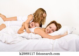 Happy morning - woman and kids on the bed