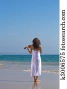 girl playing violin on beach