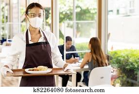 Asian waitress serving food new normal.