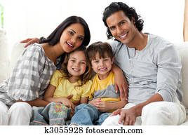 Joyful family watching TV  together sitting on a sofa