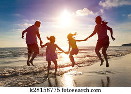 happy family jumping together on the beach