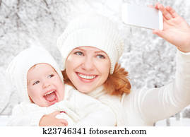 selfie  in winter. happy family mother with daughter and photographed self on  mobile phone