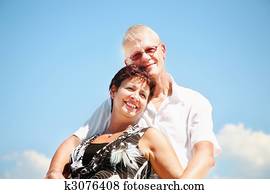 Mature couple on blue sky background