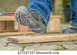 Worker with safety boots steps on a nail Worker with safety boots steps on a nail