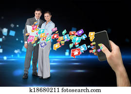 Digital composite of hand holding smartphone with app icons and business partners behind