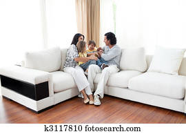 Jolly family watching TV on sofa