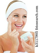 Jolly woman putting cosmetic cream
