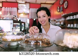 owner of a small business store showing her tasty cakes owner of a small business store showing her tasty cakes