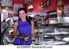 owner of a small business store showing her tasty cakes owner of a small business store showing her tasty cakes
