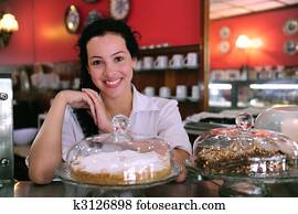 owner of a small business store showing her tasty cakes owner of a small business store showing her tasty cakes