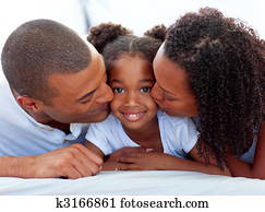 Loving parents kissing their daughter