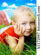 Smile of happy cute child in spring grass 